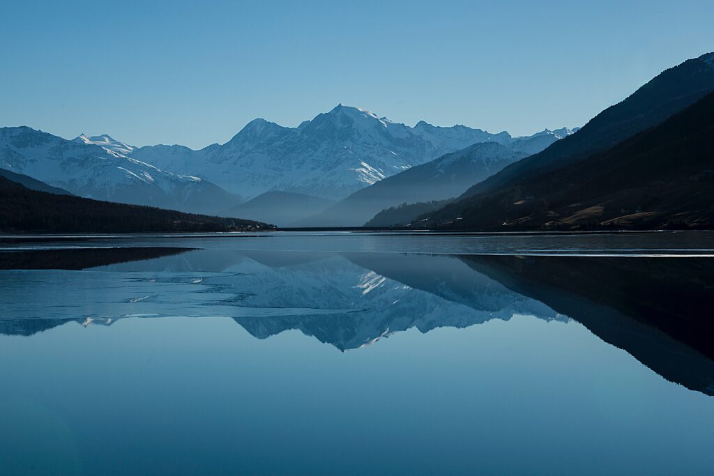 Mountain lake reflecting snow-capped peaks