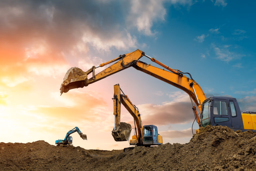 Excavators working on a construction site at sunset