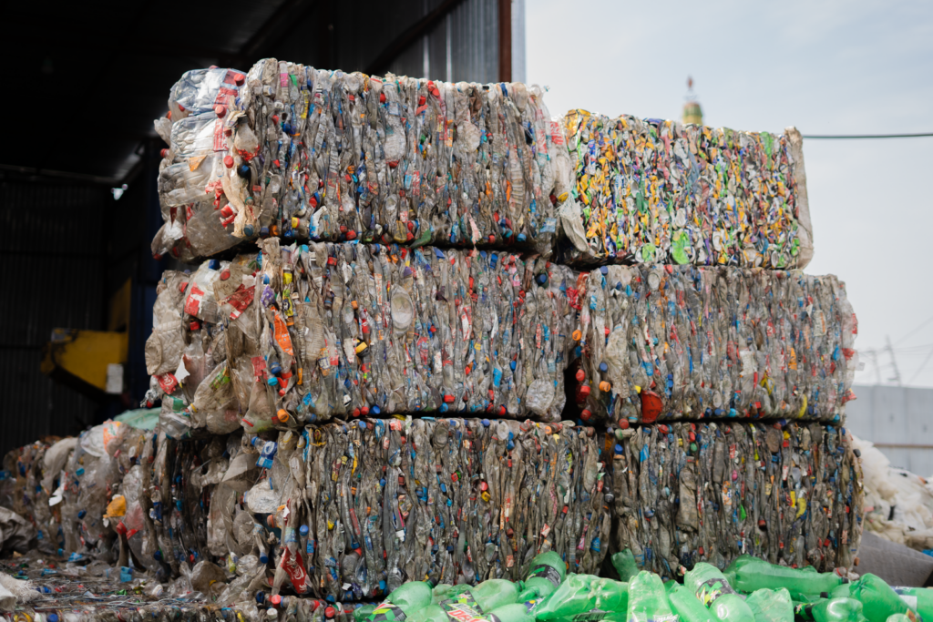 Stacked bales of compressed plastic bottles at a recycling facility