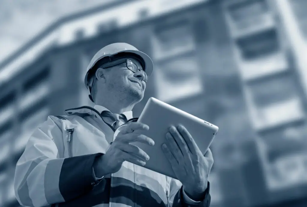 Engineer in a hard hat holding a tablet