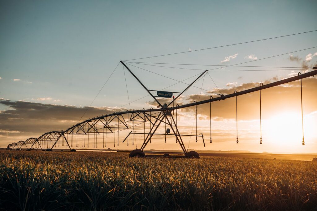 Large irrigation system stretching across a green field at sunset