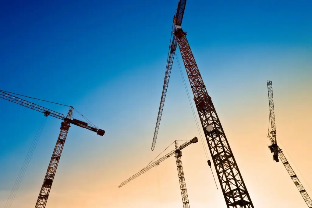 Tower cranes against a sunset sky
