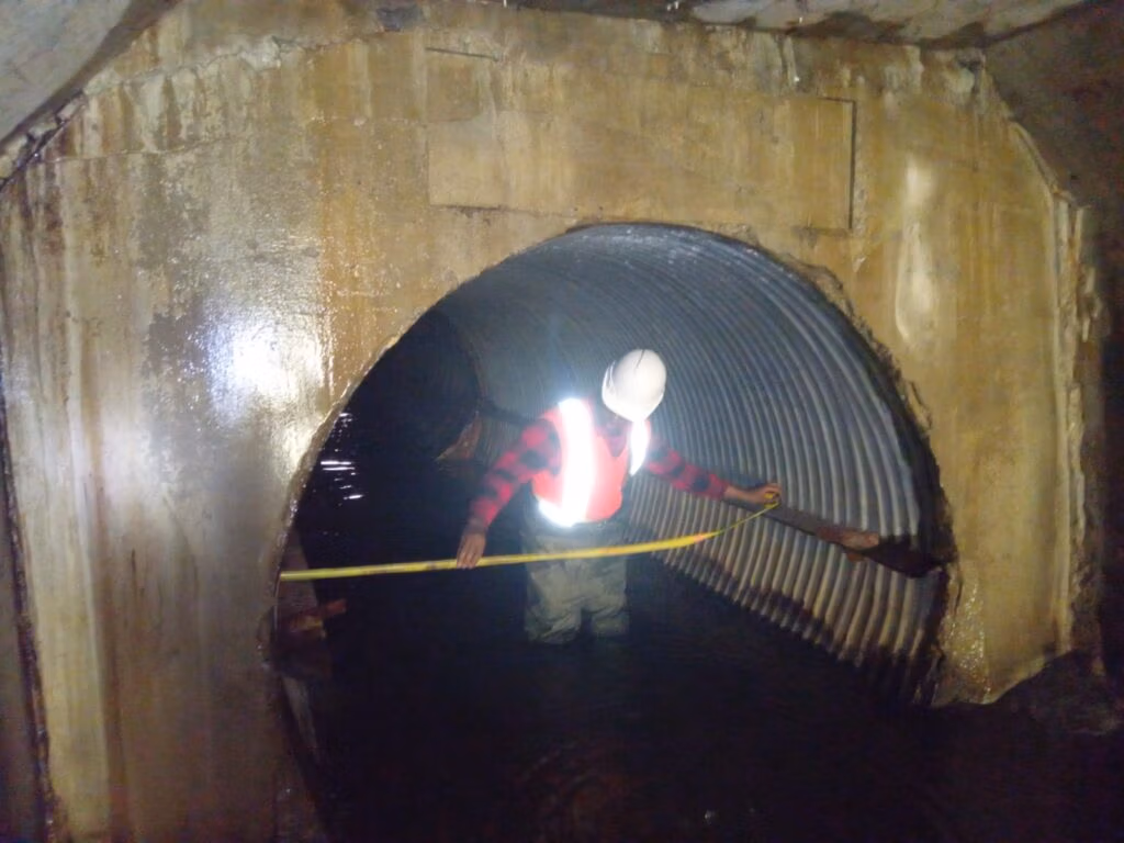 Inspector inside a corrugated steel culvert, Prescott and Russell Rollin culvert design